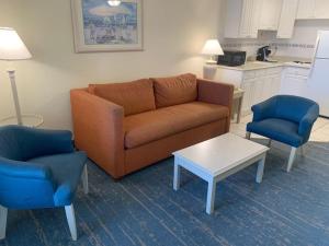 a living room with a couch and two chairs and a table at Coastal Hideaway Oceanview Condo in Daytona Beach