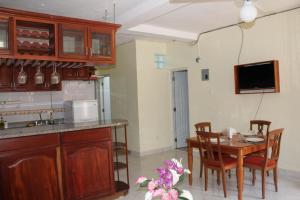 a kitchen with a table and chairs and a television at Apartamentos VBERMOR in Santo Domingo