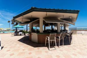 a bar on the beach with chairs and umbrellas at Coastal Hideaway Oceanview Condo in Daytona Beach