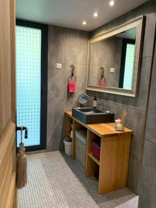 a bathroom with a sink and a mirror at Les Trigones du Causse -Maison atypique avec Piscine Privée in Saint-Martin-Labouval