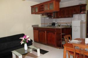 a living room with a couch and a table with flowers at Apartamentos VBERMOR in Santo Domingo
