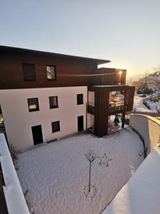 um edifício com neve no chão à sua frente em Ferienwohnung Deluxe Sattendorf em Sattendorf