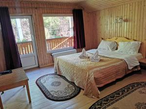 - une chambre avec un lit et 2 fenêtres dans l'établissement Pensiunea Valea Cetatii, à Râșnov