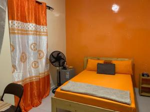 a bedroom with a bed with an orange curtain at Jacetnouche in Dakar