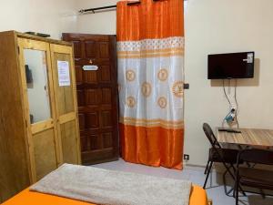 a room with a door and a curtain and a table at Jacetnouche in Dakar