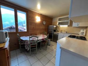 a kitchen with a table with chairs and a window at Candia 5 - Appartement en duplex dans le centre in La Clusaz