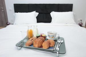a tray with pastries and drinks on a bed at Joumaya Luxury Gauthier in Casablanca