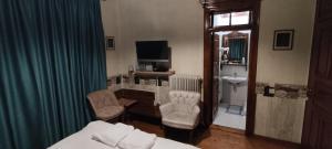 een hotelkamer met een bed en twee stoelen en een wastafel bij Guesthouse Kazakou in Dhimitsana