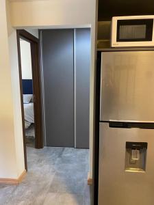 a kitchen with a stainless steel refrigerator and a microwave at AIKEN 16 Terraza in San Martín de los Andes