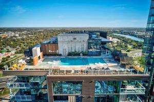 an aerial view of a building with a swimming pool at Upscale Rainey St Condo Homes - Peloton, gym, rooftop pool, wifi included in Austin