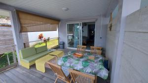 patio ze stołem i kanapą na pokładzie w obiekcie Studio Vaimiti pour 2 personnes vue mer et Moorea w mieście Faaa