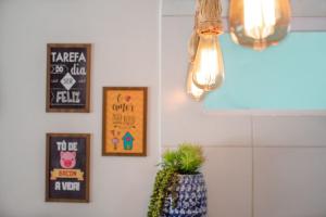 a room with pictures on the wall and a plant at Incrível casa na praia de Camurupim por Carpediem in Nísia Floresta
