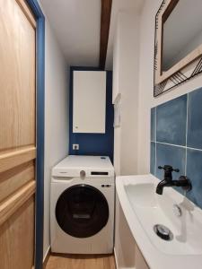 małą łazienkę z pralką i umywalką w obiekcie Triplex avec vue sur place du centre historique. w mieście Foix