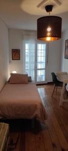1 dormitorio con 1 cama y 1 mesa con silla en Vivienda acogedora y moderna en pleno centro de Burgos, en Burgos