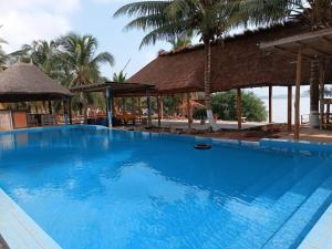 a large blue swimming pool next to a resort at Hotel Restaurant Chez Theo in Bopa