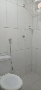 a white bathroom with a toilet and a shower at Pousada Ribeirinha in Aparecida