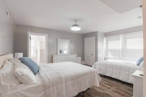 ein weißes Schlafzimmer mit 2 Betten und einem Fenster in der Unterkunft Full House Beach Block Sleeps 26 Ocean views in Ventnor City