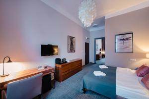 a hotel room with a bed and a desk and a computer at Aparthotel Old Town in Kraków +27 photos