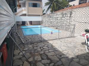una piscina con una niña en frente de un edificio en Casa encantadora em João pessoa, en João Pessoa