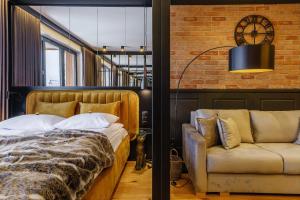 1 dormitorio con 1 cama y 1 sofá en APARTAMENT CHICAGO - stylowy apartament o bardzo wysokim standardzie w centrum miasta, z prywatnym zadaszonym parkingiem - IZBY PODHALAŃSKIE, en Nowy Targ