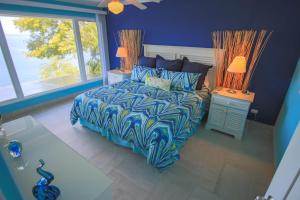 OcotalにあるBahia Pez Vela Resortの青いベッドルーム(ベッド1台、ランプ2つ付)