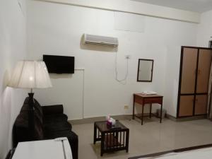 Victoria Guest House في بهاوالبور: غرفة معيشة مع أريكة ومكيف