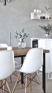 a dining room with a wooden table with white chairs at Arctic Riverside Villa in Rovaniemi
