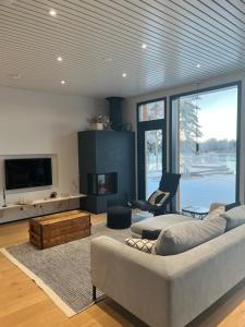 a large living room with a couch and a tv at Arctic Riverside Villa in Rovaniemi