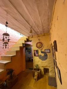 un pasillo de un edificio con escaleras y una pintura en la pared en Saffron Homestay en Jaisalmer