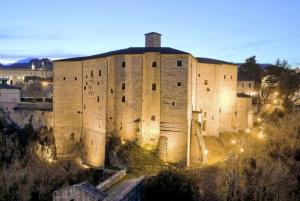 un gran edificio de ladrillo con luces. en B&B Mosca Bianca, en Ascoli Piceno