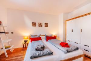 ブラウンラーゲにあるHarz Cottage Braunlageのベッドルーム(赤い枕の大きな白いベッド付)