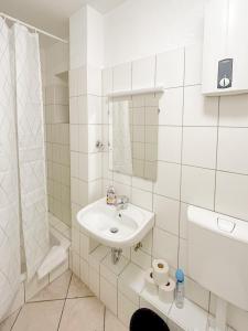 uma casa de banho branca com um lavatório e um chuveiro em RAJ Living - 1 Room Monteur Apartments - 25 Min Messe DUS em Duisburg