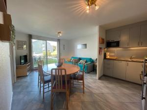 eine Küche und ein Wohnzimmer mit Tisch und Stühlen in der Unterkunft Appartement à 50m plage avec terrasse et jardin - FR-1-361-14 in Jullouville-les-Pins