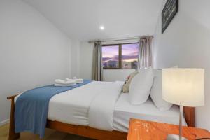 a bedroom with a white bed with a window at 3 Bdrm Mangere Delight - Parking - Wi-Fi - Netflix in Auckland