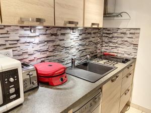 a kitchen with a sink and a stove and a toaster at Appartement Saint-Pair-sur-Mer, 1 pièce, 2 personnes - FR-1-361-40 in Saint-Pair-sur-Mer