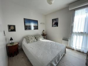 ein weißes Schlafzimmer mit einem Bett und einem Fenster in der Unterkunft Appartement Granville, 3 pièces, 4 personnes - FR-1-361-66 in Granville