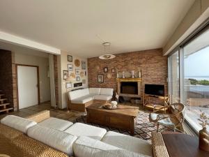 a living room with a couch and a fireplace at Villa bord de mer avec jardin et Wifi gratuit - FR-1-361-76 in Saint-Pair-sur-Mer