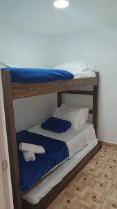 - 2 lits superposés avec des draps et des serviettes bleus et blancs dans l'établissement viviendas turísticas Sara Angel R2, à Salento