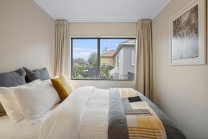 a bedroom with a bed with a large window at Gorgeous 2BR Central Akl Retreat - WI-FI - Netflix in Auckland