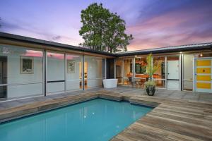 a house with a swimming pool and a patio at Countryside Calm Getaway with pool and deck in Auckland