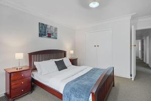 um quarto com uma cama grande e uma cabeceira em madeira em Homey Hideaway 3 BR w Parking , Wi-fi and Netflix em Auckland