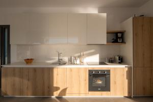 a kitchen with white cabinets and an oven in it at Haven Villa in Ierápetra