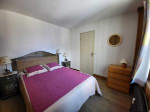 a bedroom with a large bed with a purple blanket at Appartement Tignes, 2 pièces, 6 personnes - FR-1-449-108 in Tignes
