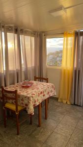 a dining room with a table and chairs and a window at Cozy 1 BR w/ balcony, ocean view & perfect sunsets in Ribeira Brava