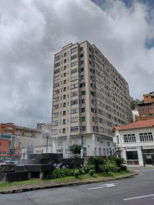 a large white building on the side of a street at Apartamento no coração de Poços de Caldas in Poços de Caldas