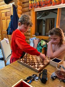 two children playing a game of chess at a table at Montana Hill Guest Ranch in Bridge Lake