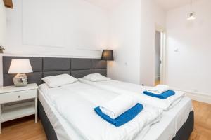 - une chambre avec un grand lit blanc et des serviettes bleues dans l'établissement Apartament Polna by Your Freedom, à Varsovie