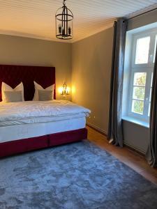 a bedroom with a large bed and a chandelier at Gutshauszimmer Premium Doppel in Neu Gaarz