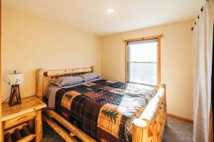 1 dormitorio con cama y ventana en Mountain Chalet, Only 3 min to Sunday River ski lifts! en Bethel