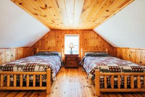 2 camas en una cabaña de madera con techo de madera en Mountain Chalet, Only 3 min to Sunday River ski lifts! en Bethel